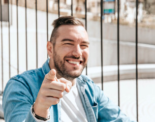 Portrait of a handsome hipster man in a jean jacket. A man in a big city on the street, a life style concept