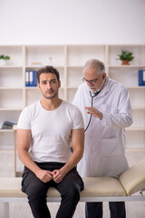 Obraz premium Young male patient visiting old male doctor