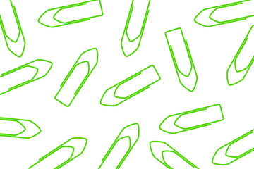 Business office pattern. A pile of green paper clips scattered on a white background	