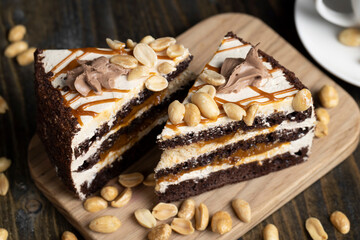 a piece of chocolate cake with caramel and peanuts