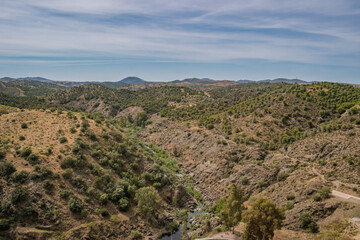 Fototapeta na wymiar Valley with vegetation in aerial view and Oeiras river and gradient mountains in the horizon, Mértola PORTUGAL 