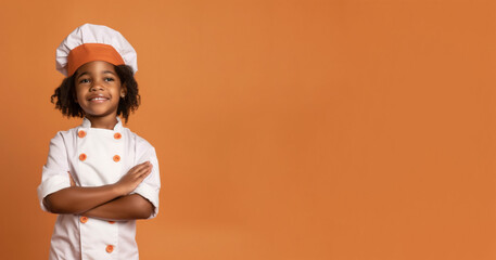 a smiling boy child dressed as a chef in soft solid orange background