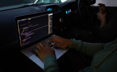 Hacker, code and laptop with person in car for ransomware, cyber security and phishing. Coding, technology and crime with hands of programmer in vehicle for fraud, network system and data at night