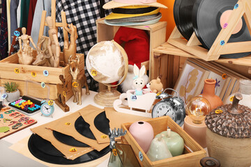 Many different stuff on white table. Garage sale