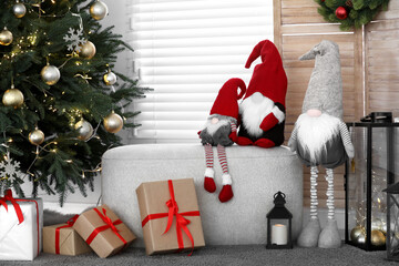 Obraz premium Cute Scandinavian gnomes, Christmas tree and gift boxes in room
