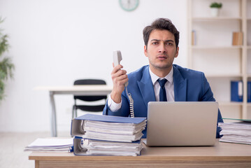 Young male employee and too much work in the office