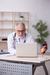 Old male doctor in telemedicine concept