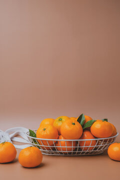 the vertical view of orange in the basket on orange background. copy space
