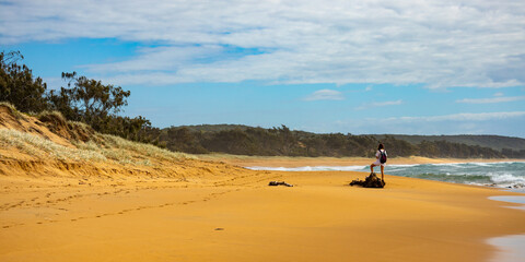 backpacker girl in white dress admiring the panorama of tropical beach in deepwater national park...