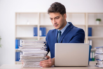 Young male employee and too much work in the office