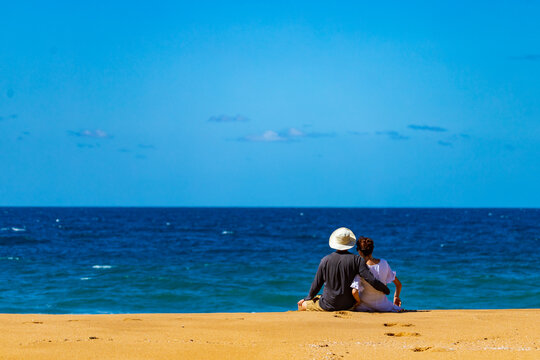 Romantic Couple Sitting On The Sand Gazing At The Sea In Deepwater National Park Near Agnes Water In Queensland, Australia; Romantic Holidays In Gladstone Region