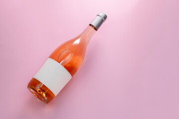 Wine bottle mockup, unopened bottle of rose wine on pink background, top view, copy space, flat lay