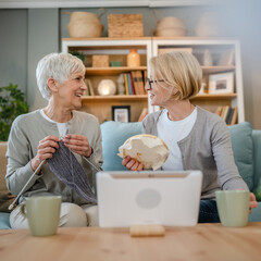 two women senior mature knitting and embroidery during leisure time