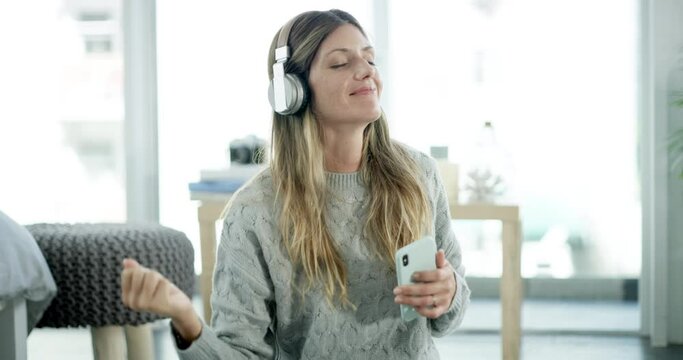 Music, headphones and woman dancing for home streaming service, mental health or happy energy on smartphone. Dance, carpet and excited person on mobile app, listening to radio or audio tech on floor