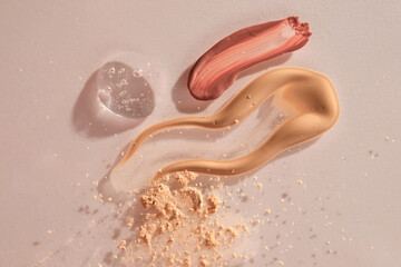 A sample of red lip gloss, foundation, powder and gel makeup base.