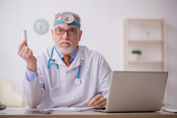Old male doctor otologist working in the clinic