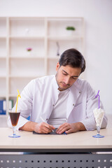 Young male chemist examining soft drink at the lab