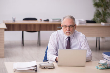 Old male employee working in the office