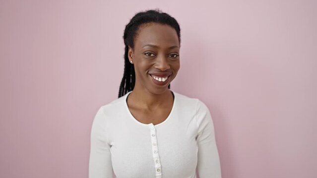 African american woman smiling confident standing over isolated pink background