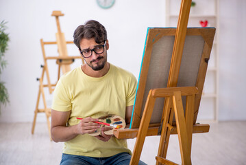 Young man enjoying painting at home