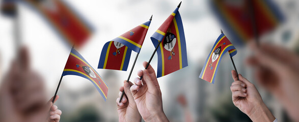 A group of people holding small flags of the Swaziland in their hands