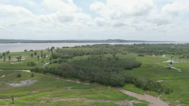 Drone shot low over wetlands and vegetation at the Amazon river, in cloudy Brazil