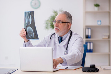 Old male doctor radiologist working in the clinic