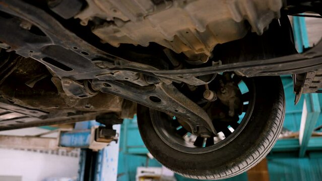 Underside of saloon lifted up to prepare for damage caused by accidents. lift is parked waiting for repairs in car repair. That has standards to be repaired by expert technicians to return to normal