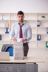 Young male employee unhappy with excessive work in the office