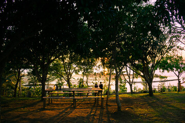 Empty bench by the sea at sunset