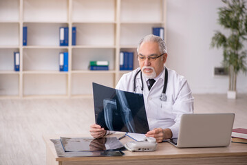 Old male doctor radiologist working in the clinic
