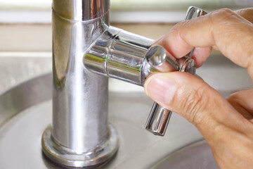 Person turning on a tap for washing hands