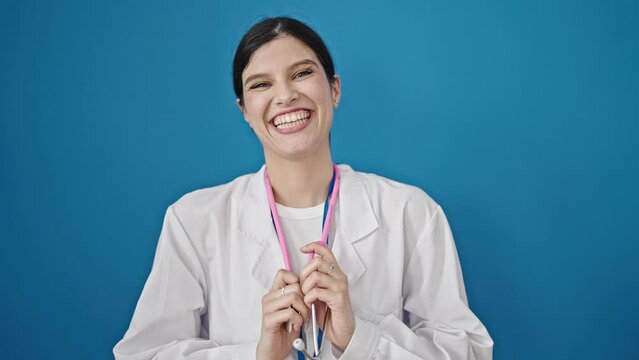 Young beautiful hispanic woman doctor smiling confident wearing stethoscope over isolated blue background