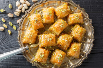 Turkish traditional delight baklava with pistachio on a dark wood background closeup. Horizontal...