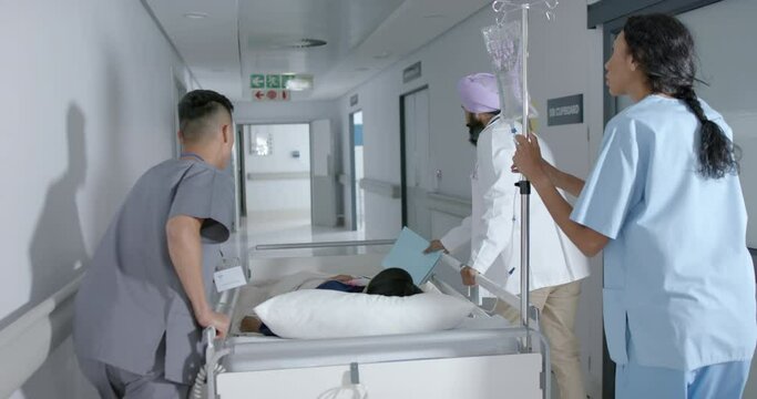 Busy diverse doctor and surgeons walking with patient on hospital bed in slow motion