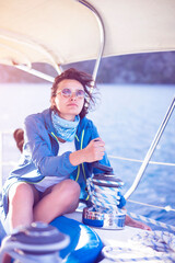 Young woman sailor winding rope on sailing winch