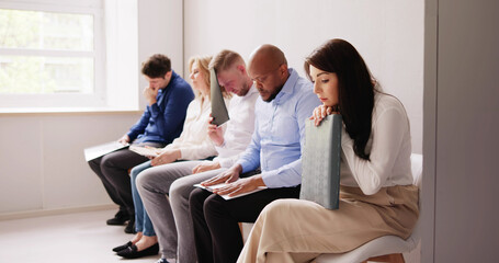 People Bored While Sitting On Chair Waiting For Job Interview