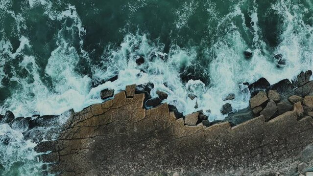 White waves of the Atlantic Ocean crashing against a rocky shore 4k