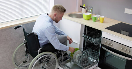 Person With Disability In Wheelchair Using Dishwasher
