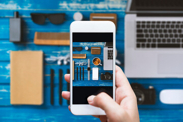 Hand taking photo of mens accesories flat lay table top