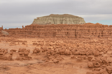 Scenic view on White Butte Looming over Red Rocks in Goblin Valley State Park, Utah, USA. Unique eroded Hoodoo Estrada sandstone rock formations. Mushroom-shaped rock pinnacles in San Rafael Swell