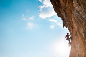 Rock climber on the background of blue sky - Powered by Adobe