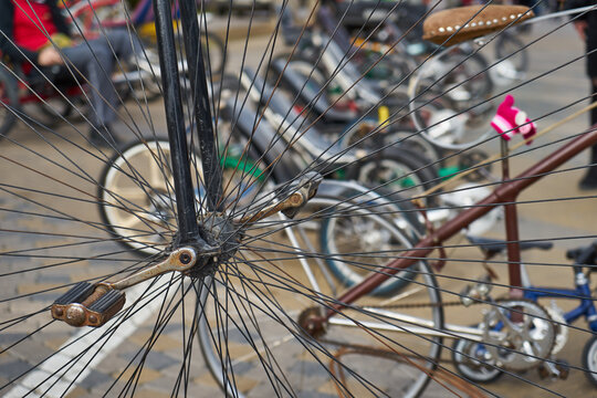 An image of a large old-fashioned bicycle wheel and pedals.