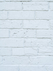 Close up. Brick wall and white surface, clean, rough, uneven surface material. Retro decoration construction and vertical image.