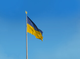 Flag of Ukraine with a trident in the blue sky