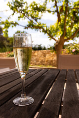 A glass of cava on a brown table, with a blurred background