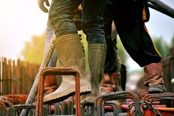 Construction worker pouring cement or concrete with pump tube at construction site