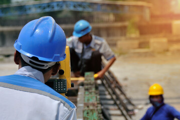 Site engineer uses theodolite at construction site. Surveyor 