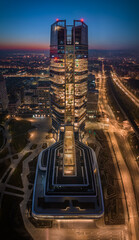 Budapest, Hungary - Aerial vertical panoramic view of Budapest's new, illuminated skyscraper MOL Campus at Kopaszi-gat by the riverbank of Buda at dusk with red and blue sky