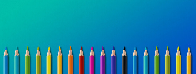 Colored pencil group isolated on blue. Panoramic banner background